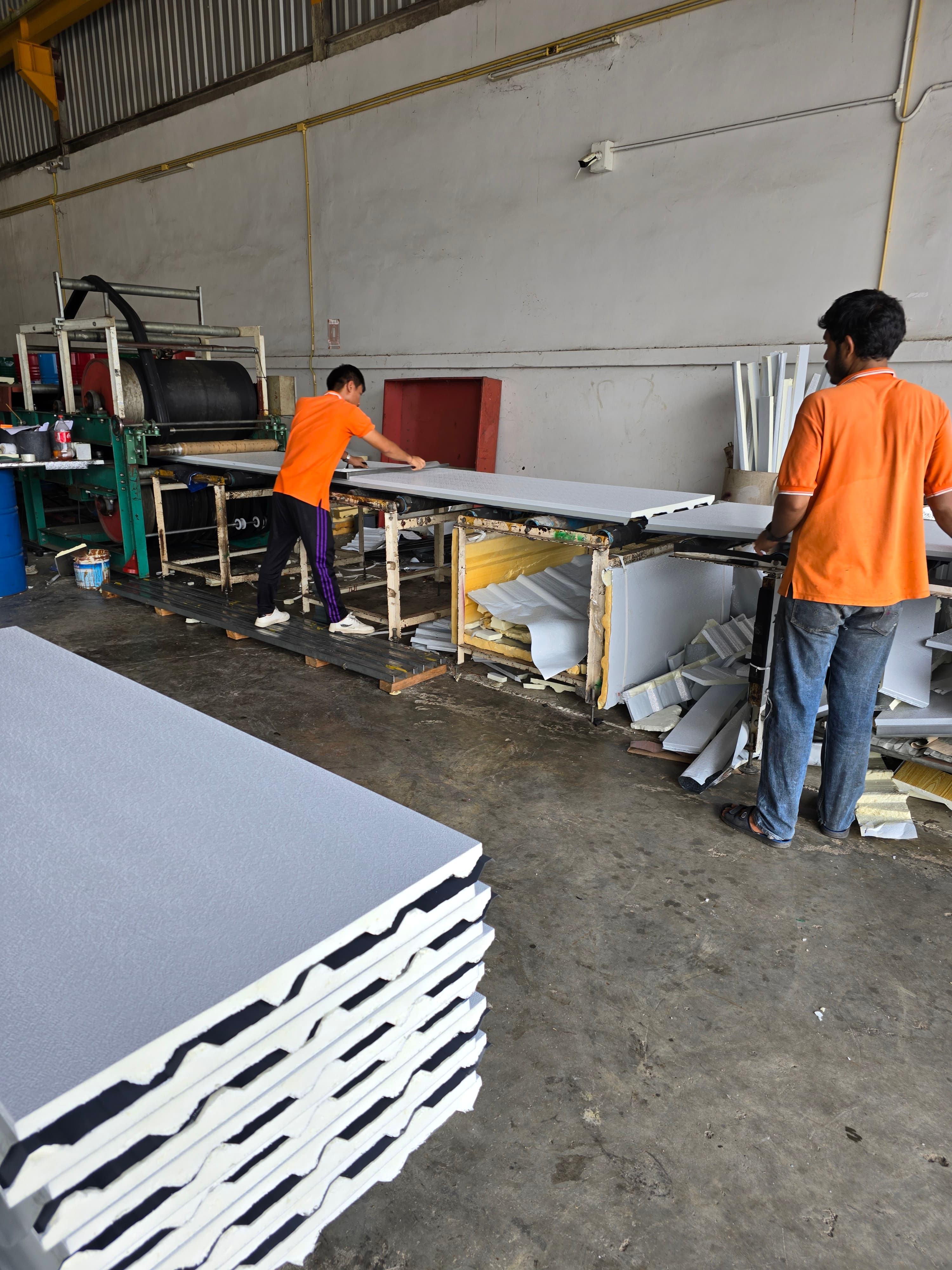 Workers handling white panels in a panel workshop