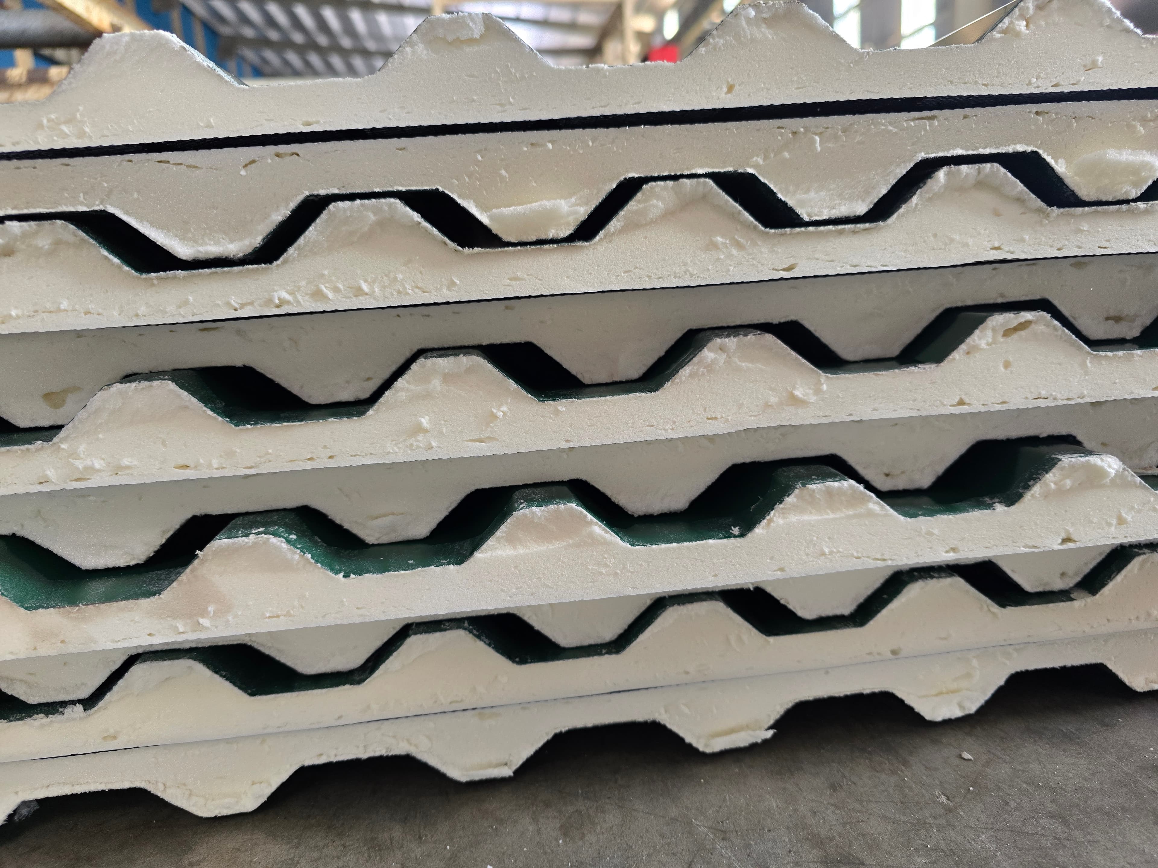 Stacked roof panels showing the polyurethane foam core between steel sheets